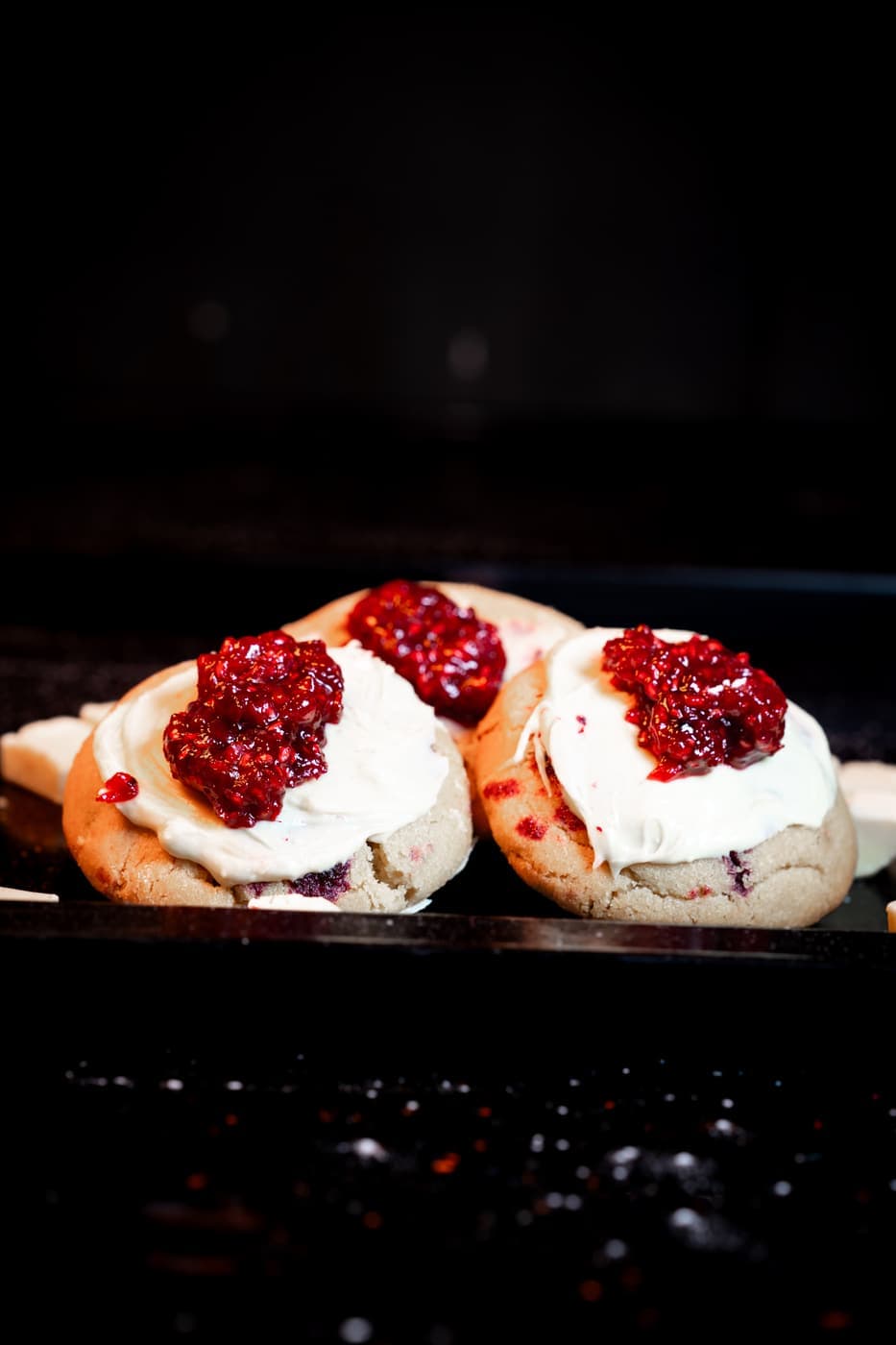 Blush Berry Cookies with a soft cream top and crushed raspberry.