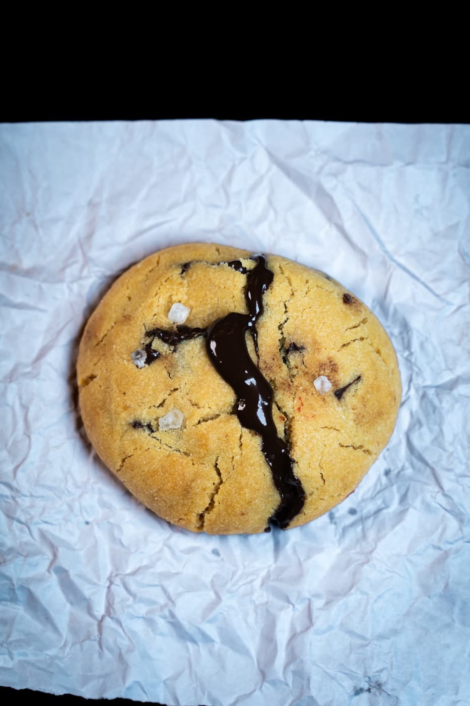 The Butter Club Chocolate Chip Cookie, split to show the molten chocolate centre and flaked sea salt.